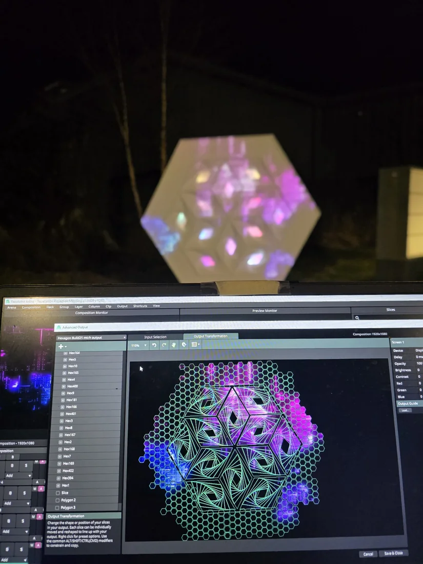 Resolume Arena's Advanced Output window mapping hundreds of hexagon slices onto a physical tessellated installation glowing in the background